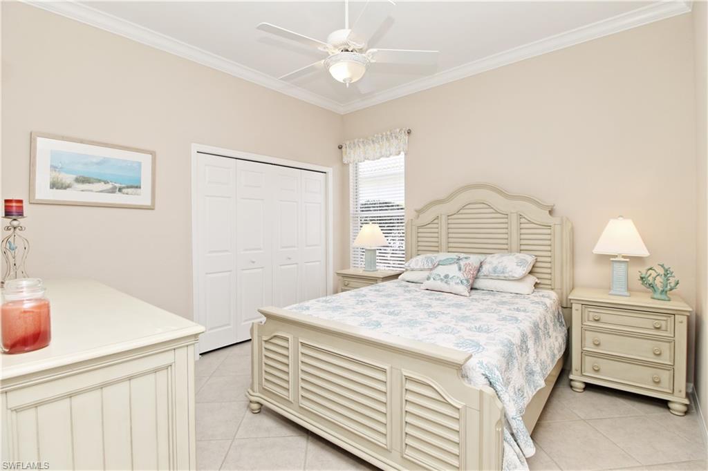 Bedroom with ornamental molding, a closet, ceiling fan, and light tile patterned floors