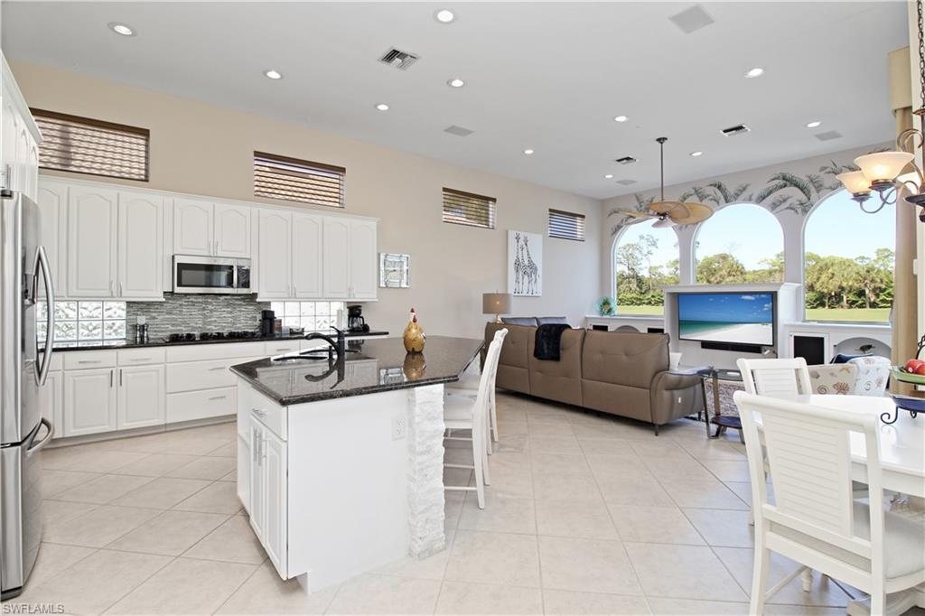 Kitchen featuring dark stone counters, white cabinetry, a kitchen island with sink, stainless steel appliances, and recessed lighting