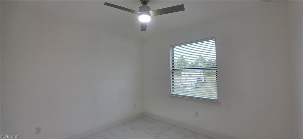Unfurnished room with light marble finish flooring and a ceiling fan
