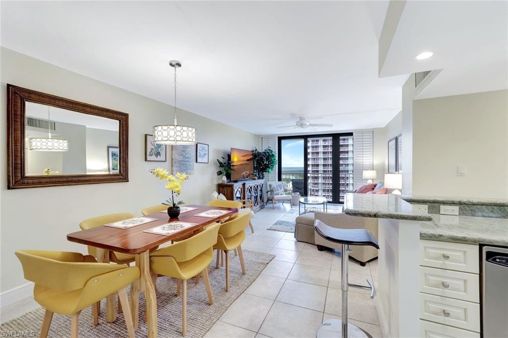 Dining space with a wall of windows, light tile patterned flooring, and ceiling fan