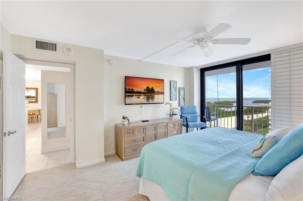 Bedroom with access to exterior, a ceiling fan, carpet, and expansive windows