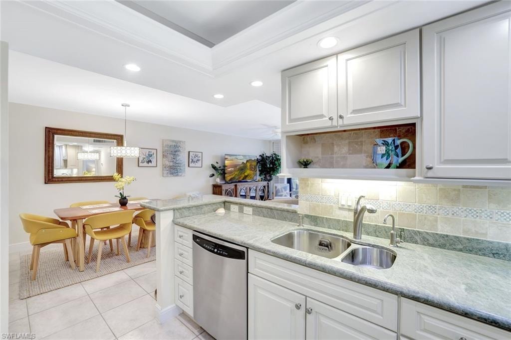 Kitchen featuring tasteful backsplash, stainless steel dishwasher, recessed lighting, decorative light fixtures, and white cabinets