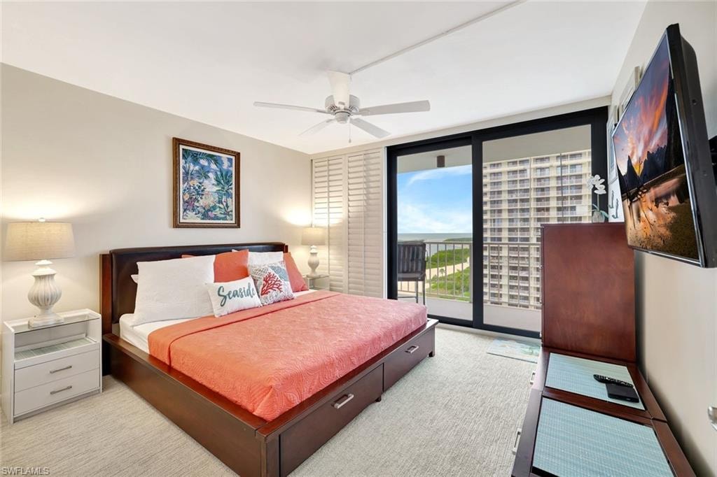 Bedroom with access to outside, a wall of windows, ceiling fan, and carpet flooring