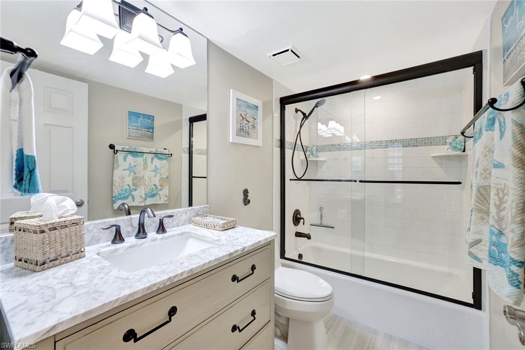 Bathroom with vanity and enclosed tub / shower combo