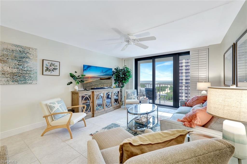 Tiled living room featuring expansive windows and a ceiling fan