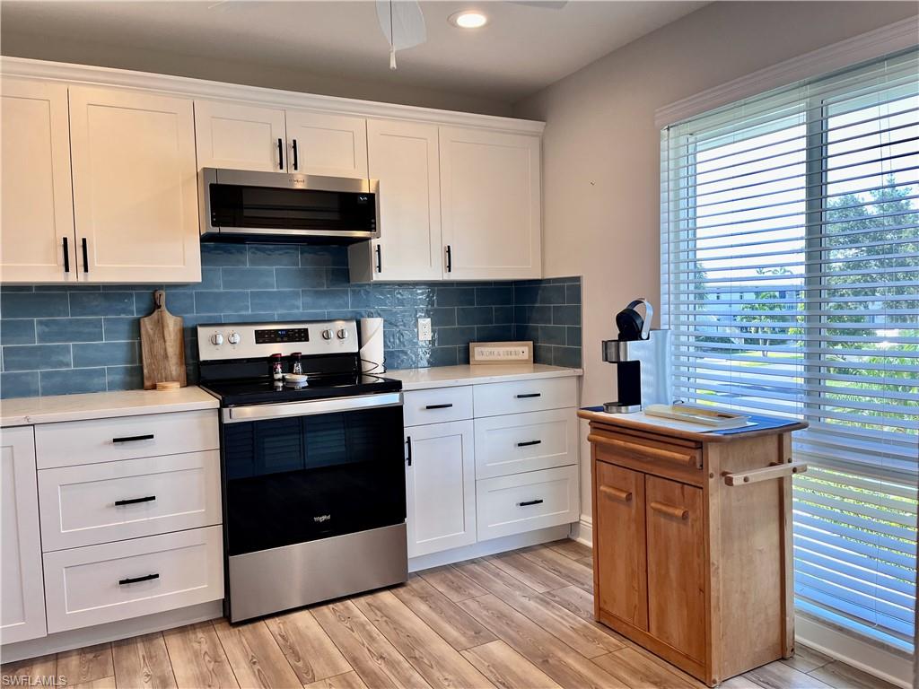 Kitchen featuring ceiling fan, stainless steel appliances, plenty of natural light, and backsplash