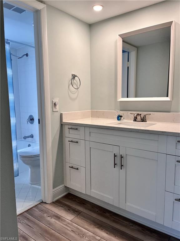 Full bathroom featuring tiled shower / bath, tile flooring, toilet, and vanity