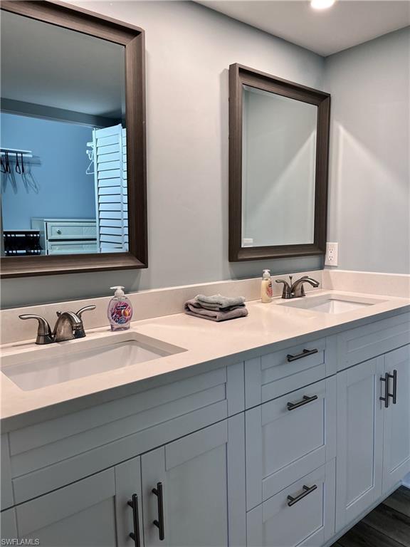 Bathroom featuring hardwood / wood-style floors, oversized vanity, and dual sinks