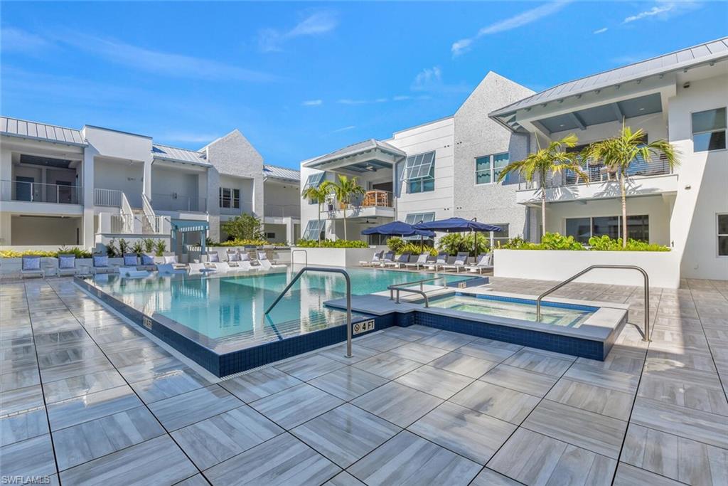 View of swimming pool with a hot tub