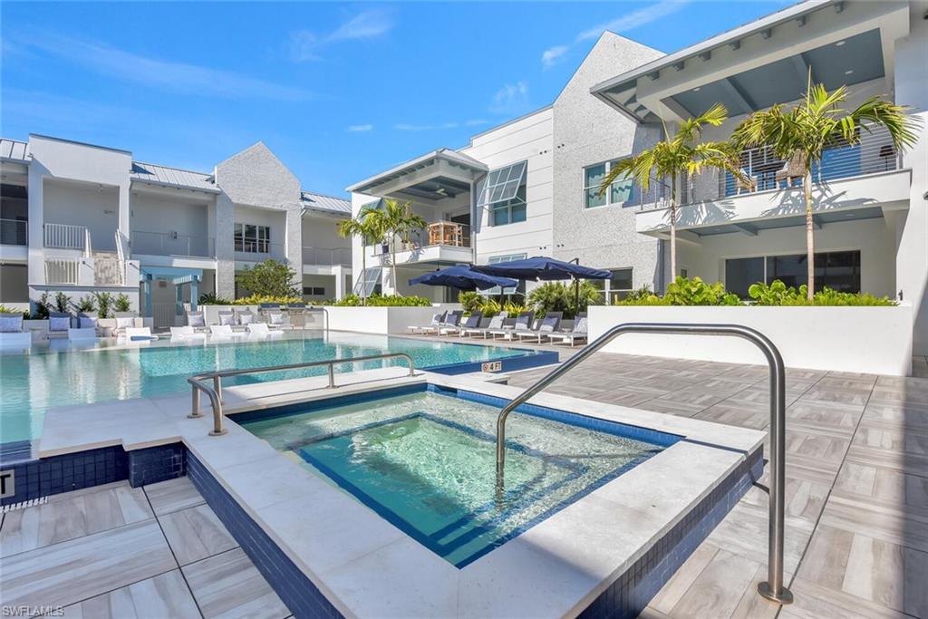 View of swimming pool with a patio area and a hot tub