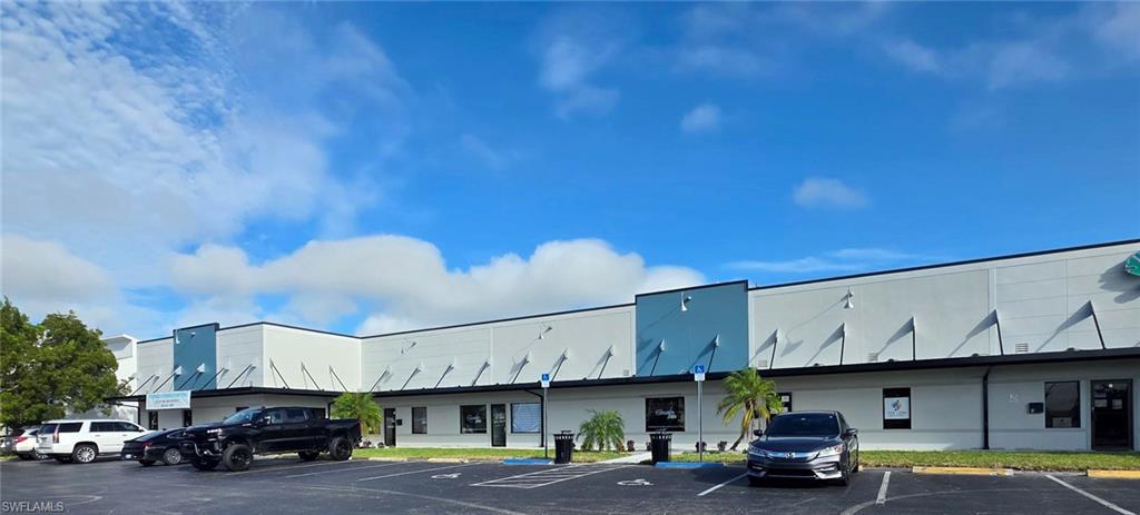 View of building exterior featuring uncovered parking