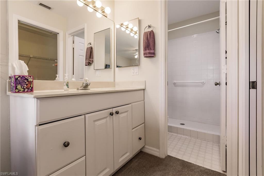 Bathroom with tiled shower and vanity