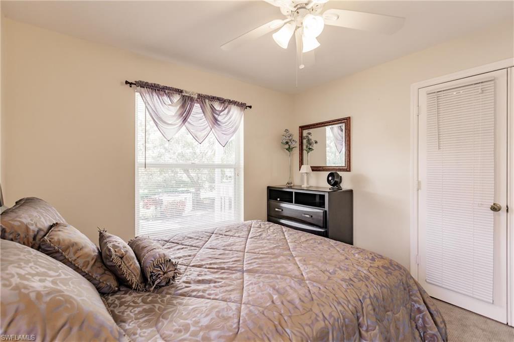 Carpeted bedroom featuring ceiling fan