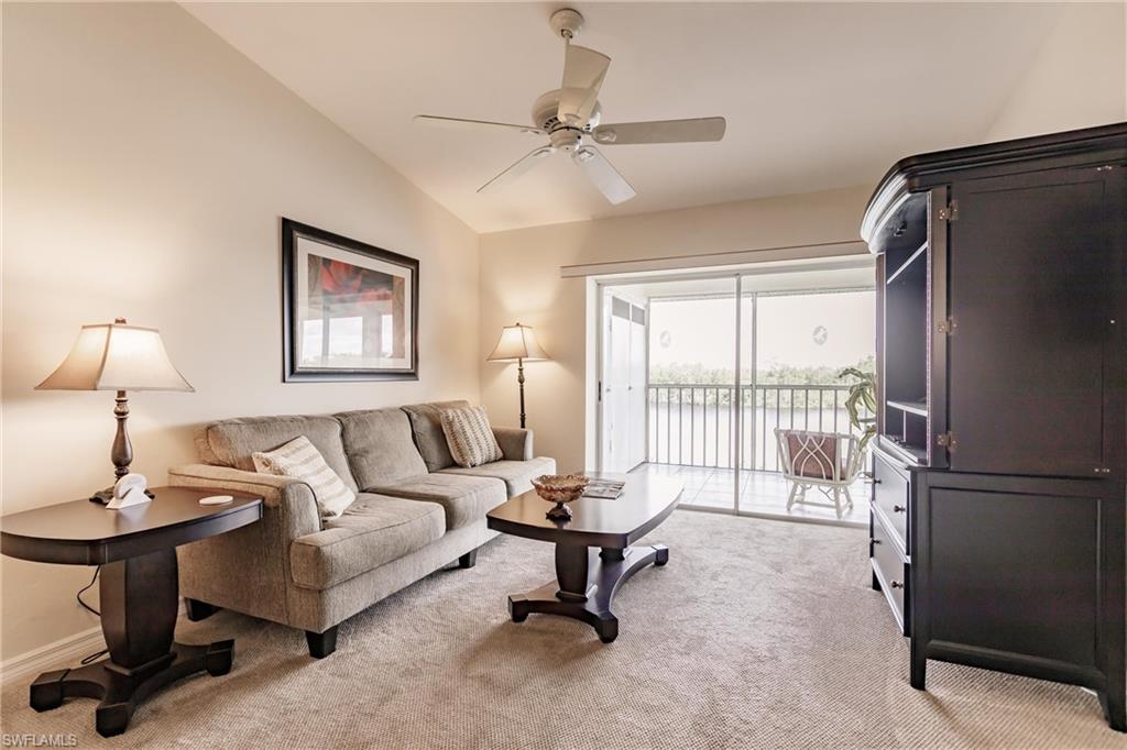 Carpeted living room featuring lofted ceiling and ceiling fan