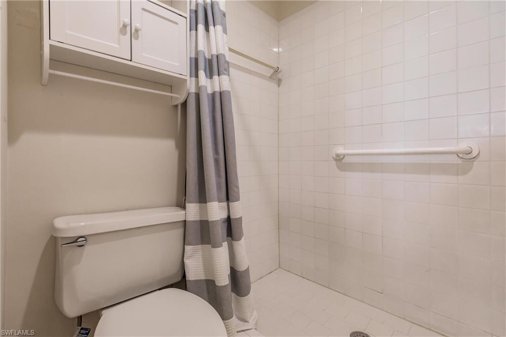 Bathroom with toilet and curtained shower