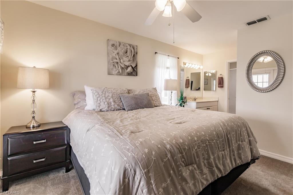 Carpeted bedroom featuring ceiling fan