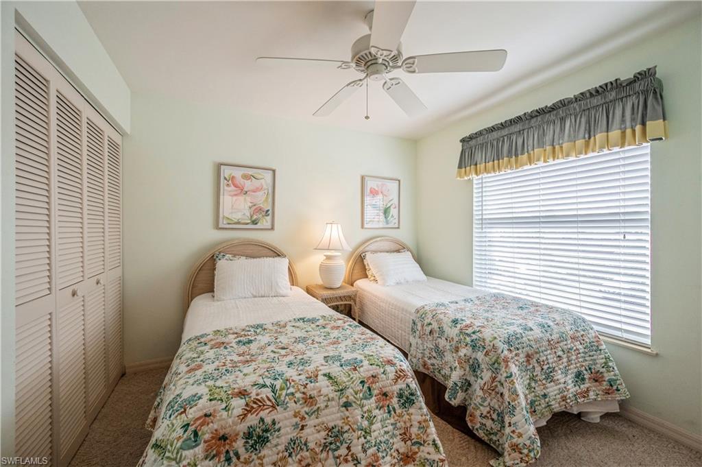 Carpeted bedroom featuring a closet and ceiling fan