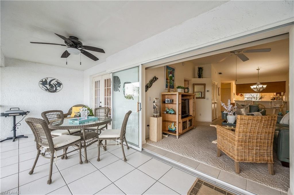 Dining space with a ceiling fan, a chandelier, and tile patterned flooring