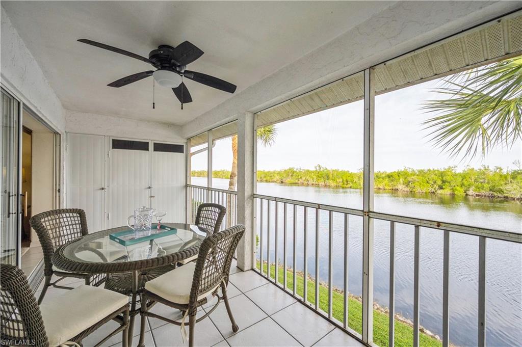 Sunroom featuring a water view, tile patterned floors, ceiling fan, and a balcony