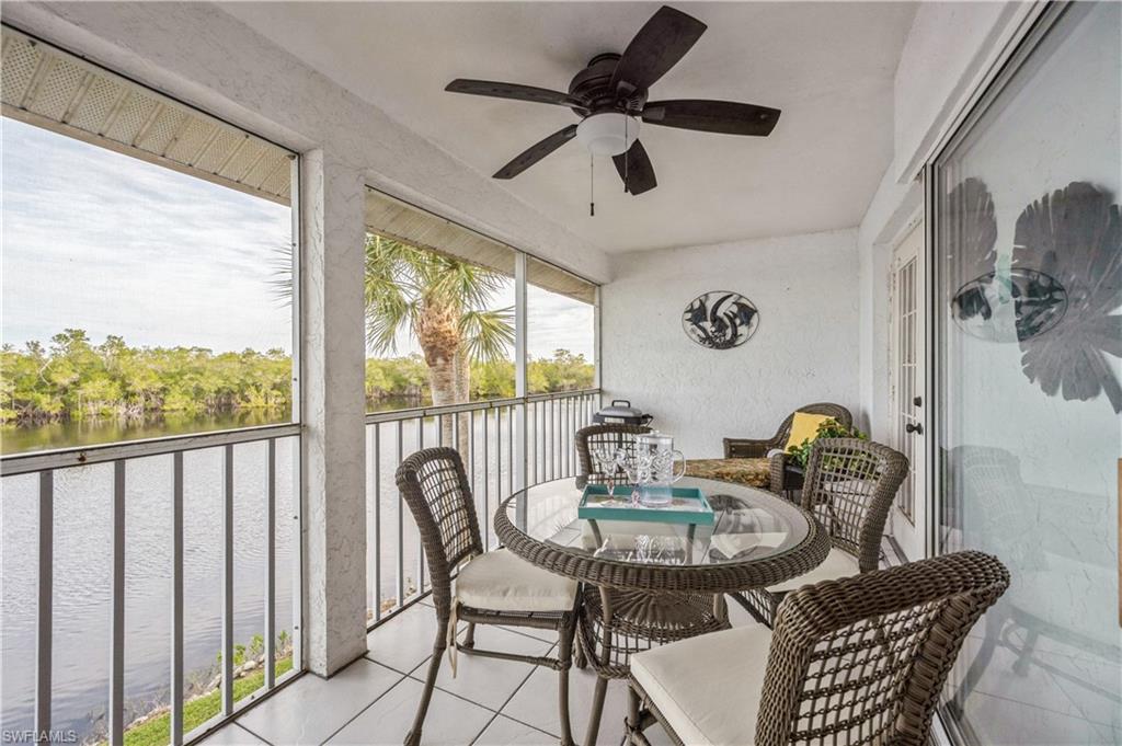 Sunroom / solarium featuring a ceiling fan, a water view, and a balcony