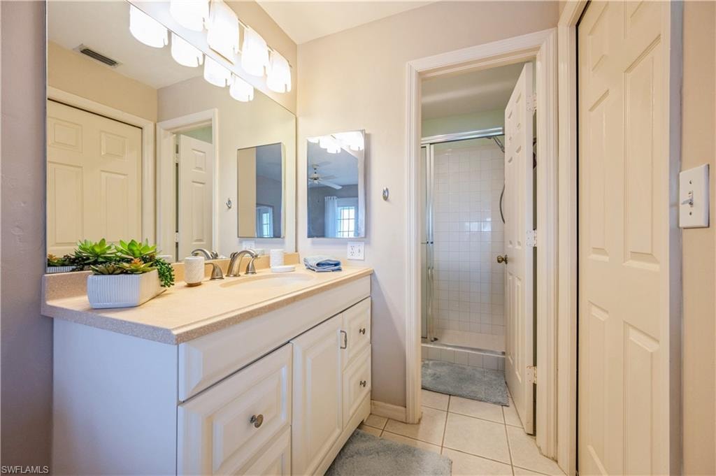 Bathroom featuring vanity, a shower stall, and light tile patterned flooring