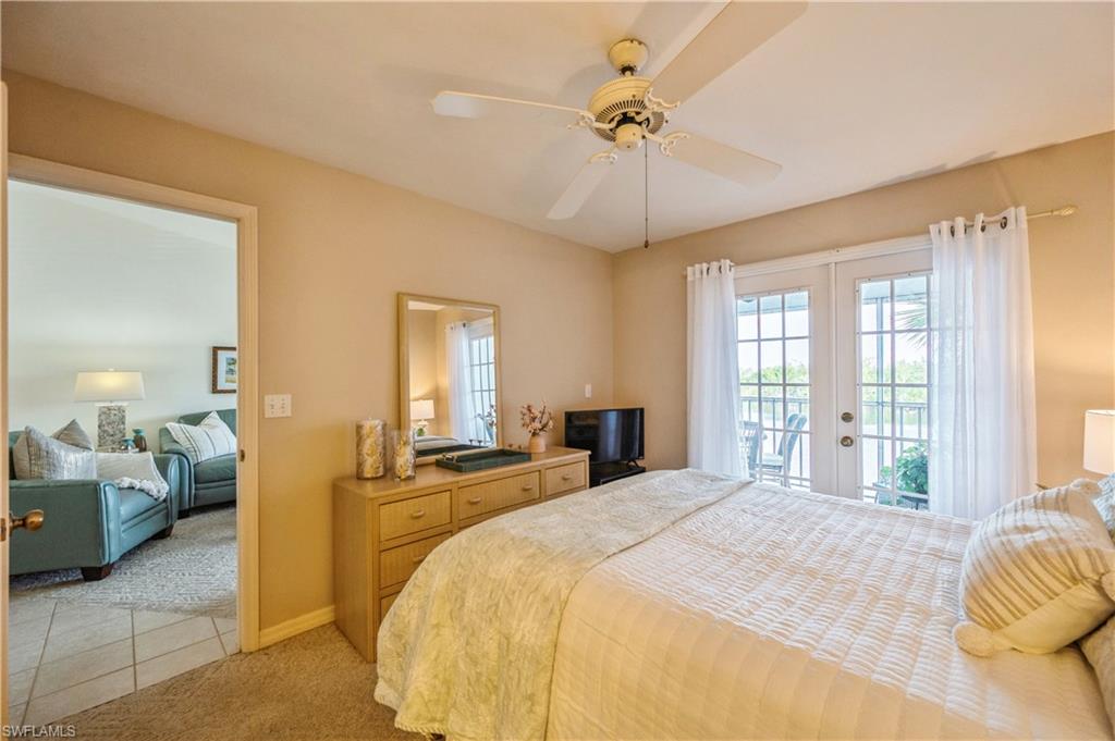 Bedroom with french doors, access to exterior, a ceiling fan, light carpet, and light tile patterned floors