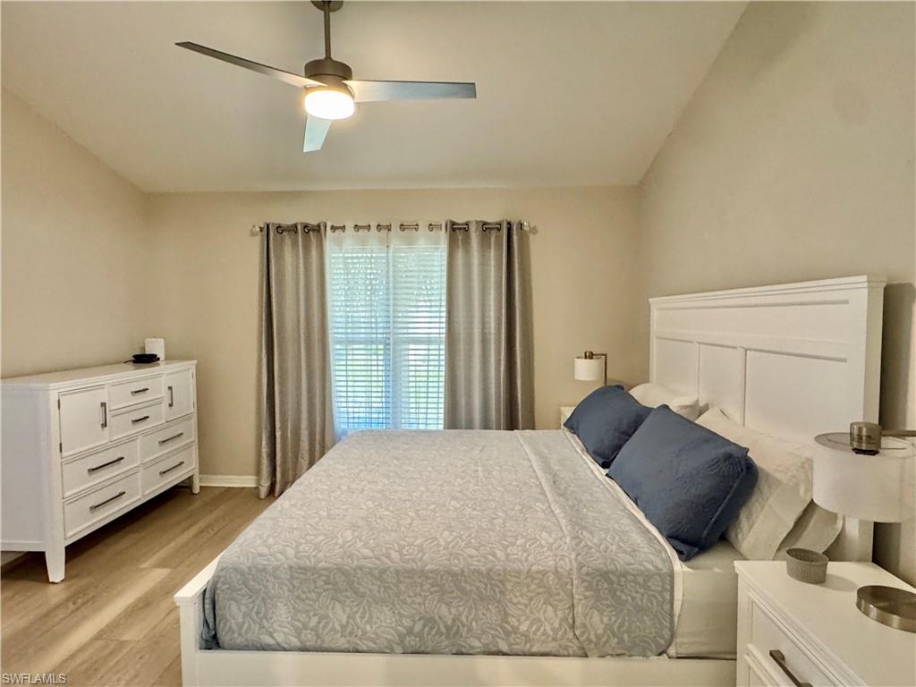 Bedroom with lofted ceiling, light wood-type flooring, and ceiling fan