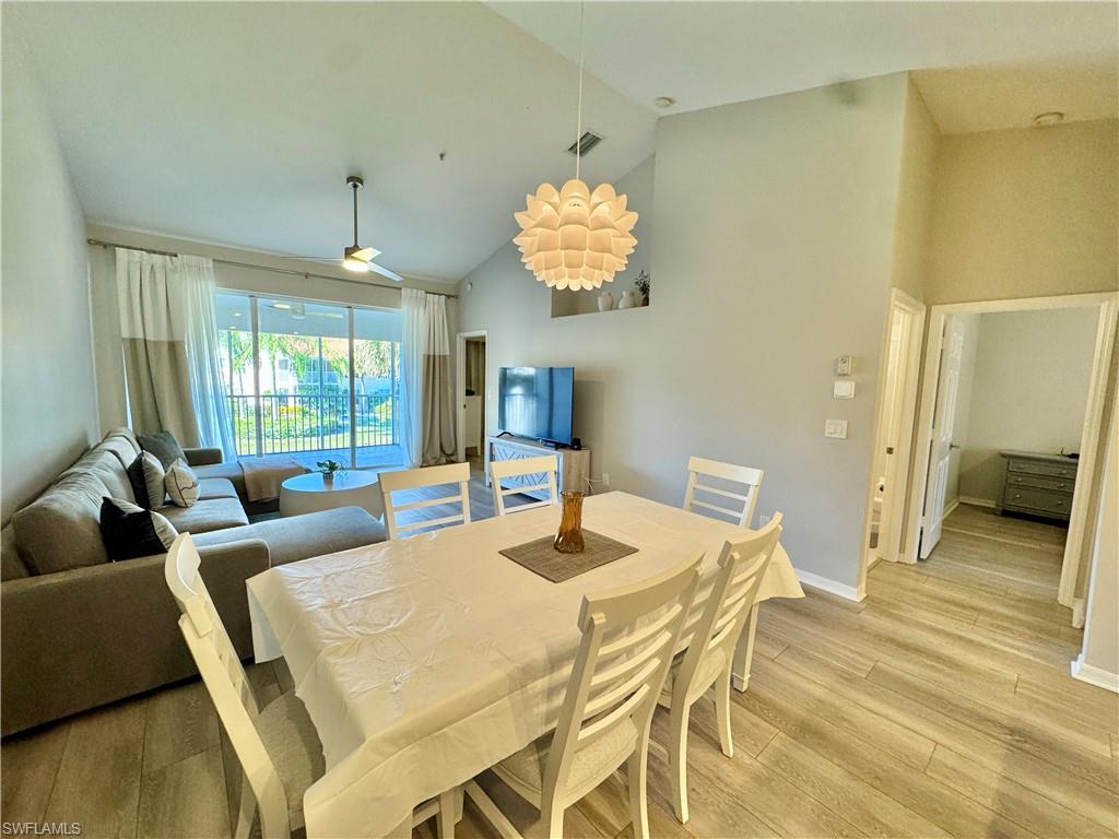 Dining space featuring high vaulted ceiling and light wood-style flooring