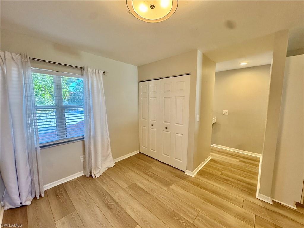 Unfurnished bedroom featuring light wood-style flooring and a closet