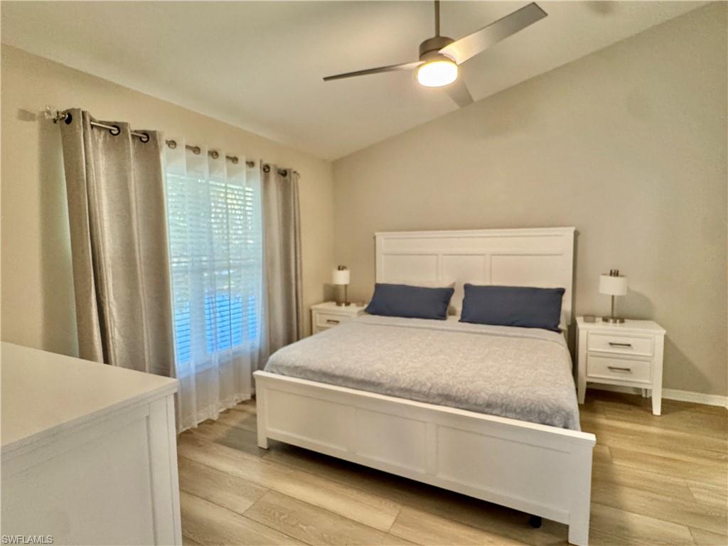 Bedroom featuring lofted ceiling, light wood-type flooring, and a ceiling fan