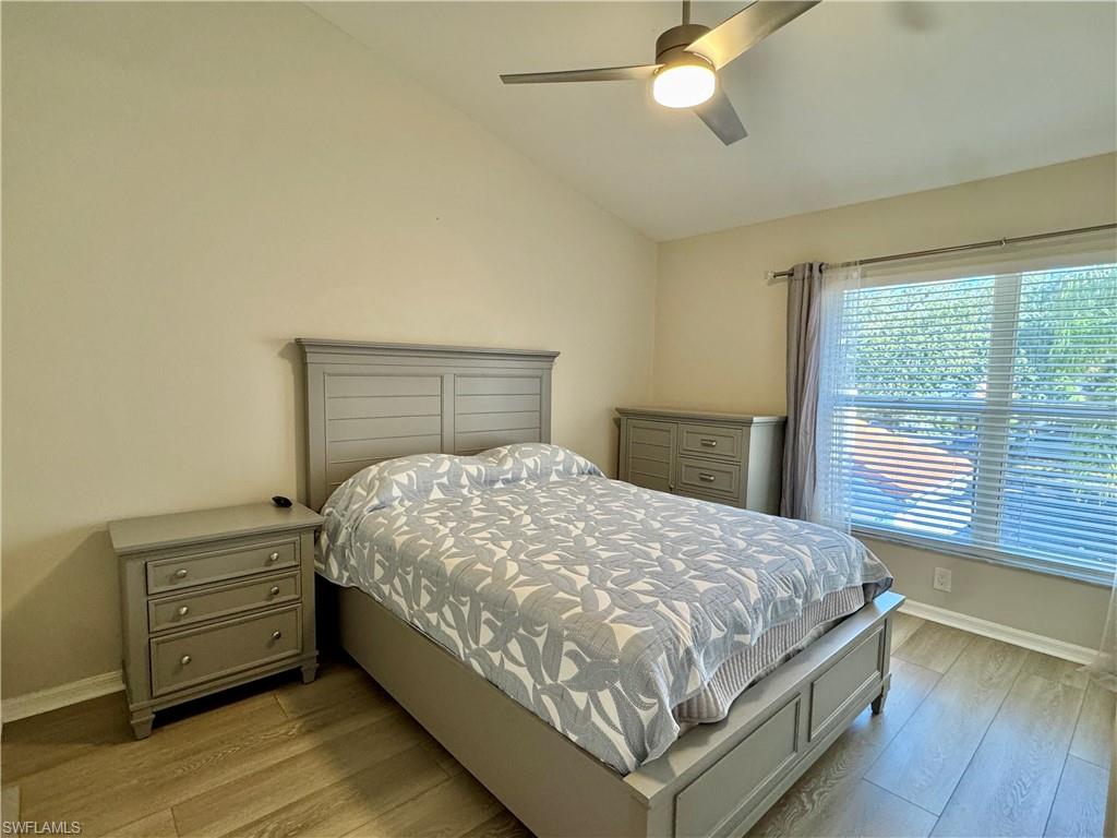 Bedroom with lofted ceiling, light wood-style floors, and a ceiling fan