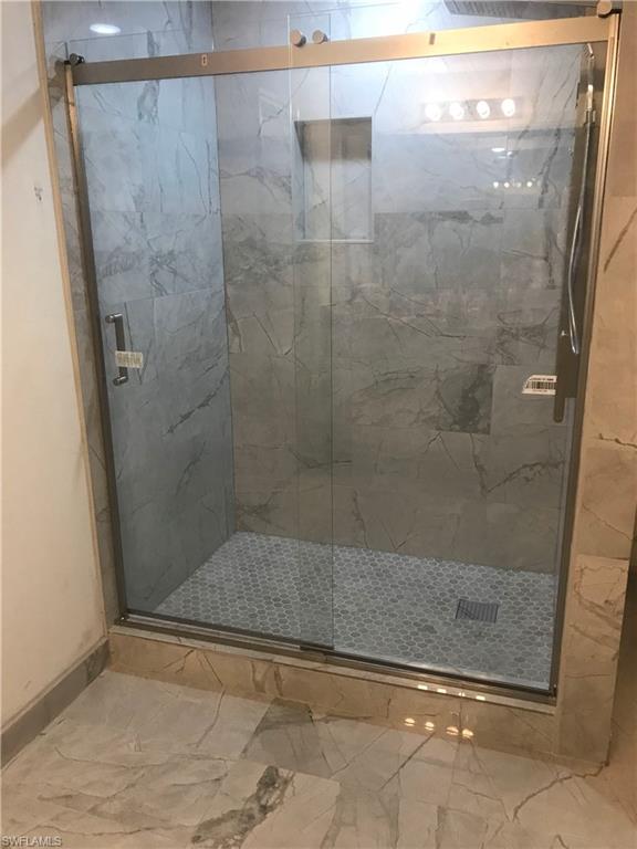 Bathroom with a marble finish shower