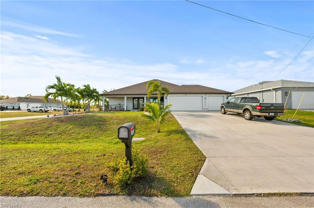 Ranch-style house featuring a front lawn, driveway, and an attached garage