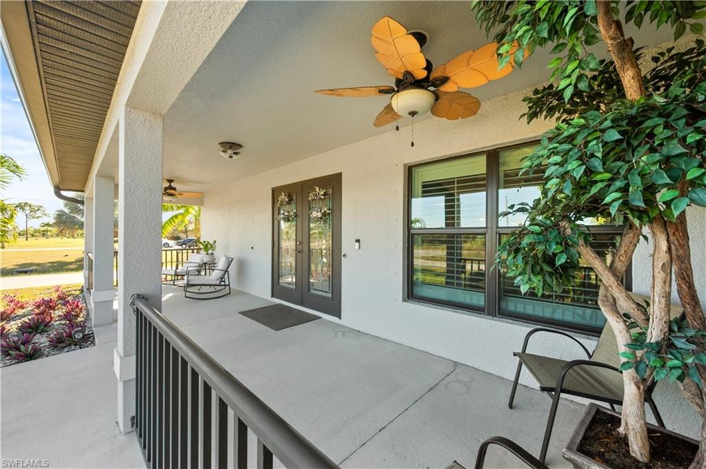 Covered porch featuring a ceiling fan and french doors