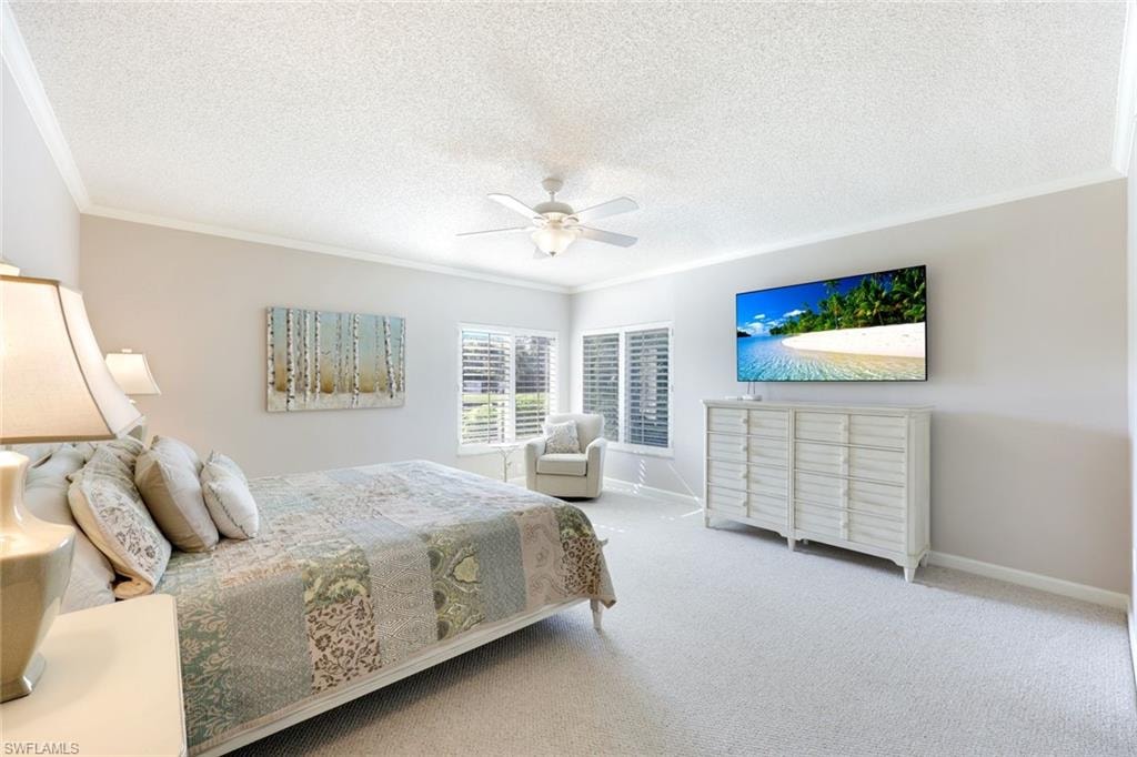 Bedroom featuring crown molding, a textured ceiling, carpet, and a ceiling fan