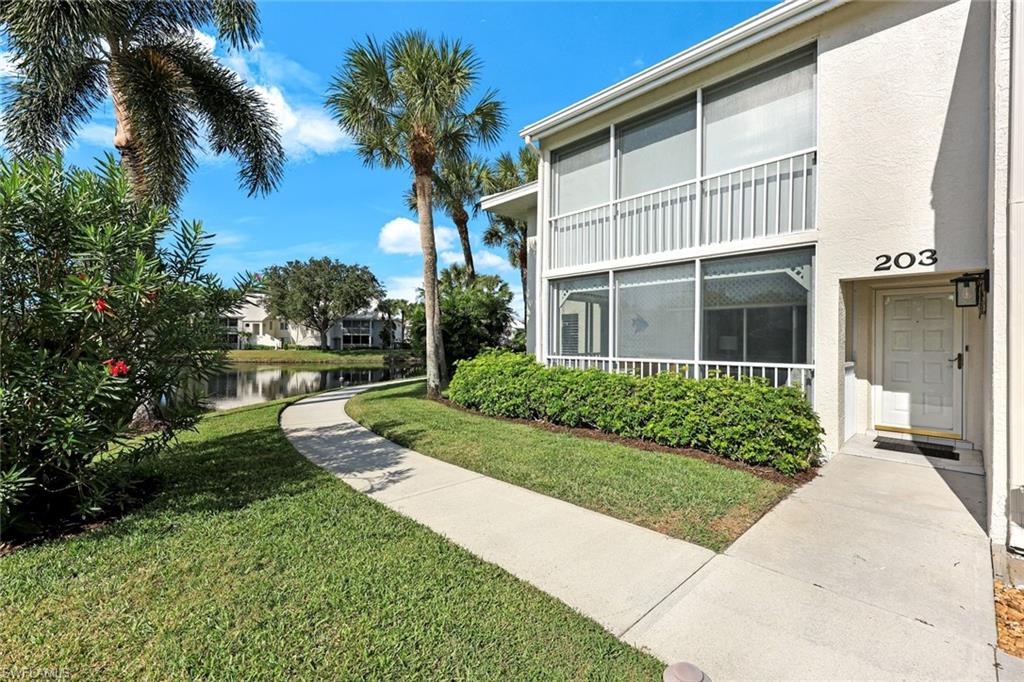 Surrounding community with a water view, a yard, and a sunroom