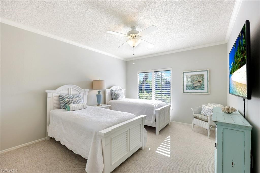 Bedroom with carpet flooring, a textured ceiling, ornamental molding, and ceiling fan