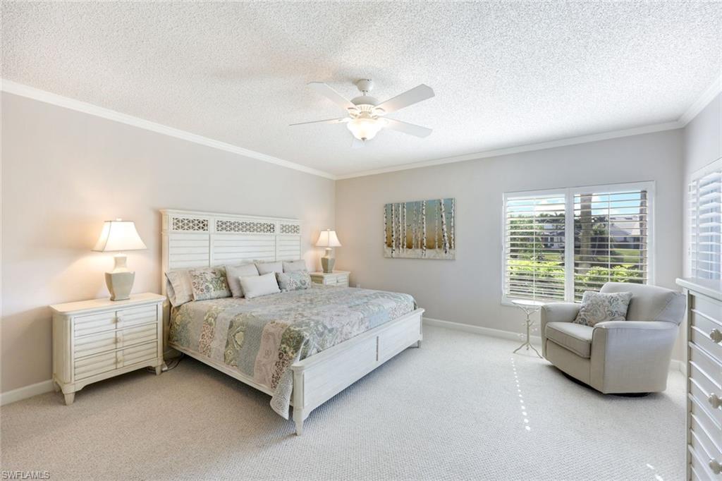 Bedroom with ornamental molding, carpet, a ceiling fan, and a textured ceiling
