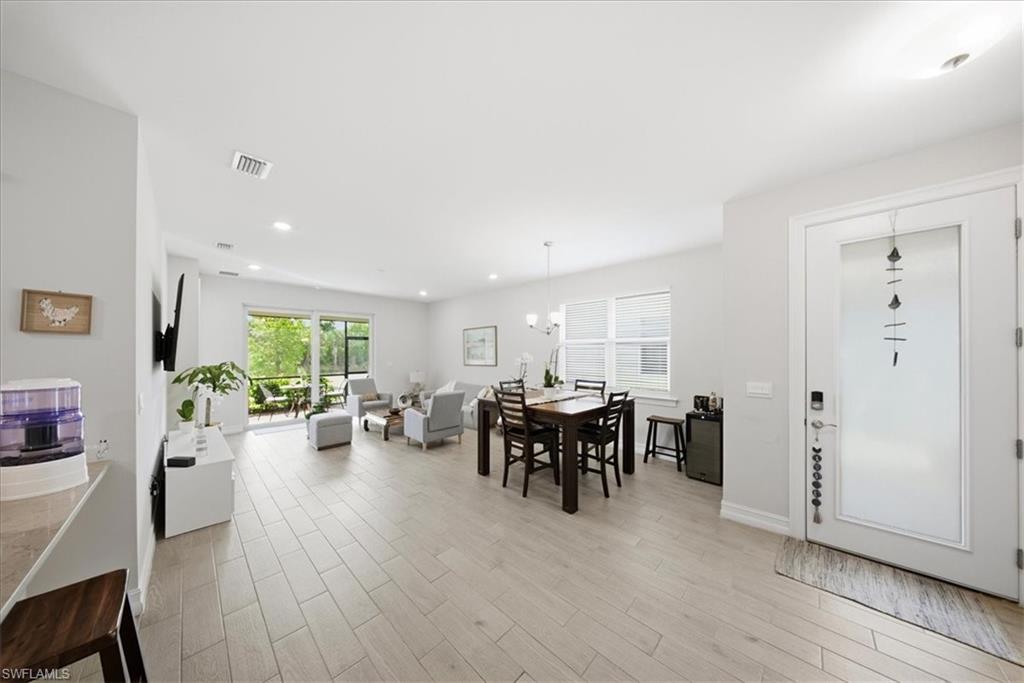 Dining room with light wood finished floors, a chandelier, and recessed lighting