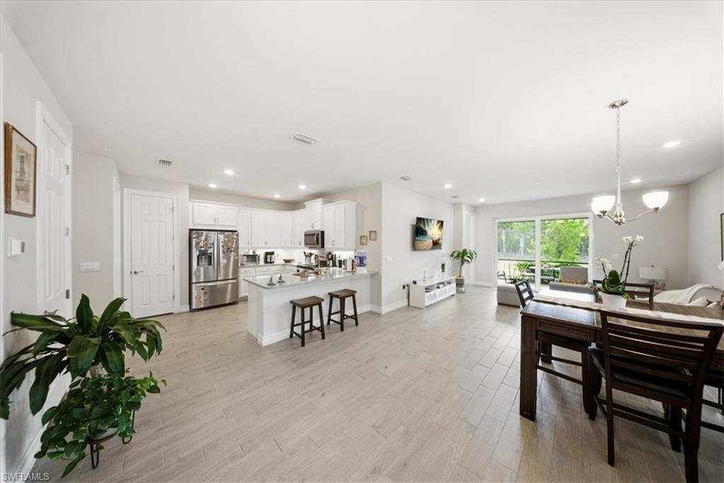 Dining space with light wood-style flooring, a chandelier, and recessed lighting