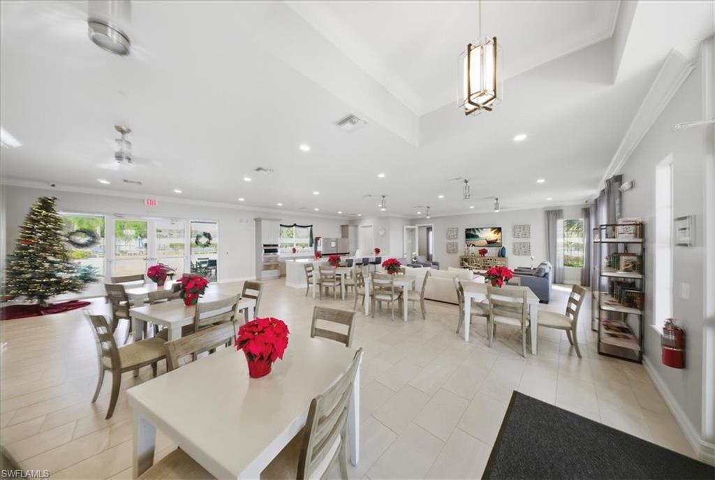 Dining space with plenty of natural light, ornamental molding, and light tile patterned floors