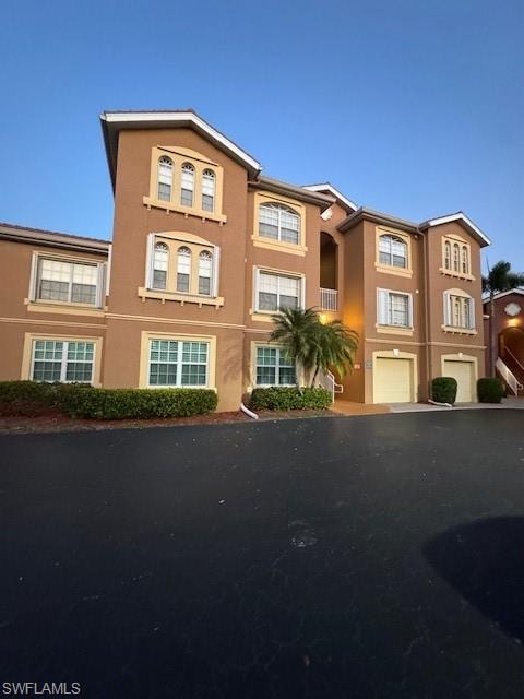 View of front of property featuring stucco siding and an attached garage