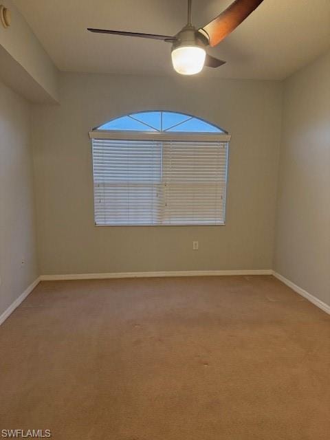Unfurnished room with light colored carpet and a ceiling fan