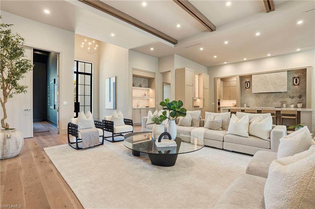Open-concept living area with high ceilings, recessed lighting, and wood-finish flooring
