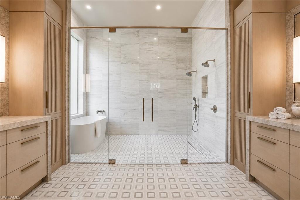 Spacious shower enclosure with clear glass paneling and dual shower heads