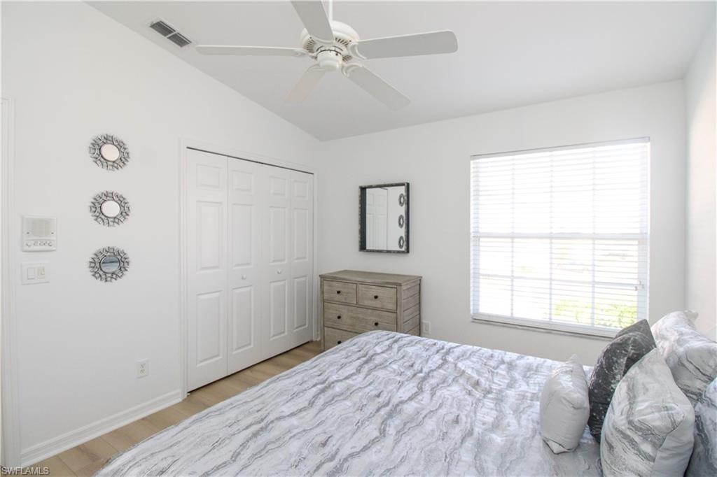 Bedroom with ceiling fan, a closet, lofted ceiling, and light hardwood / wood-style flooring