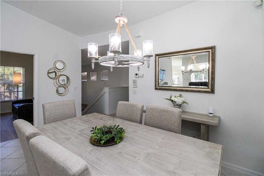 Dining space featuring tile patterned floors and an inviting chandelier