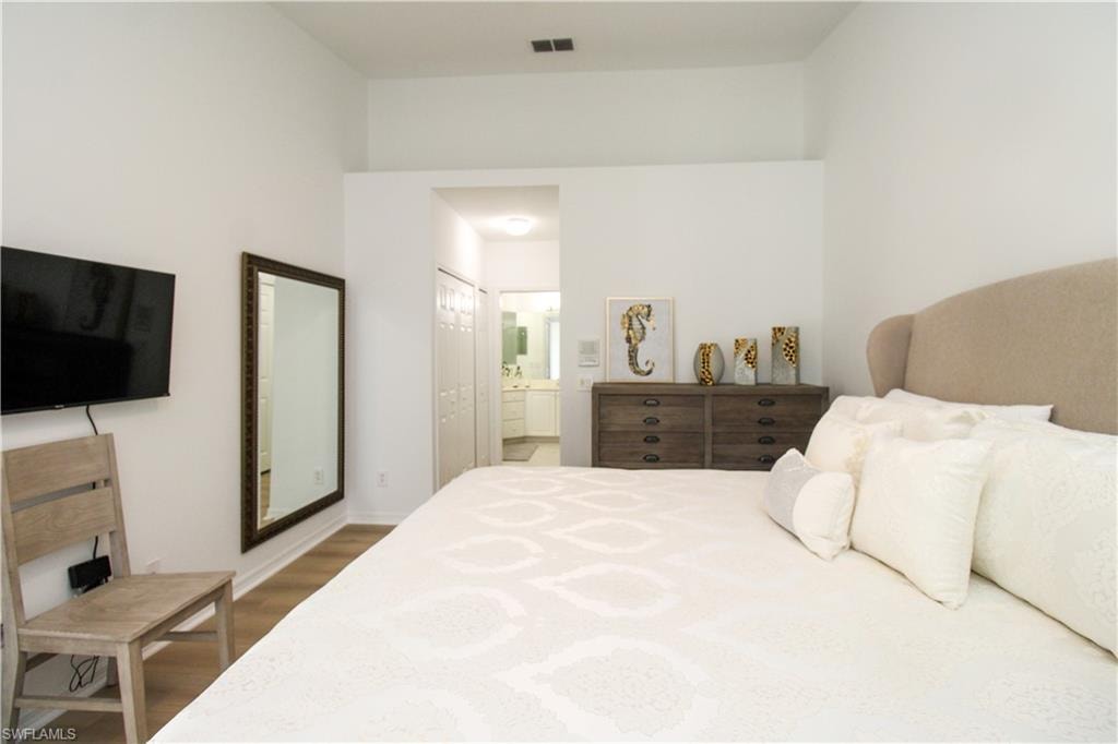 Bedroom with hardwood / wood-style flooring and ensuite bath