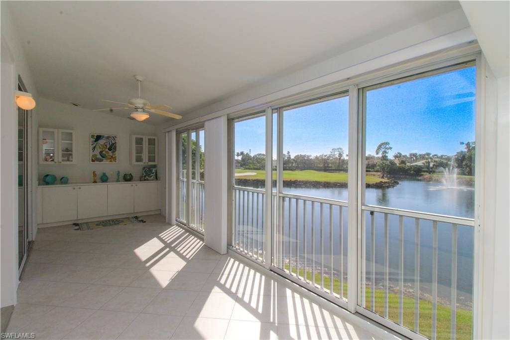 Unfurnished sunroom featuring ceiling fan and a water view