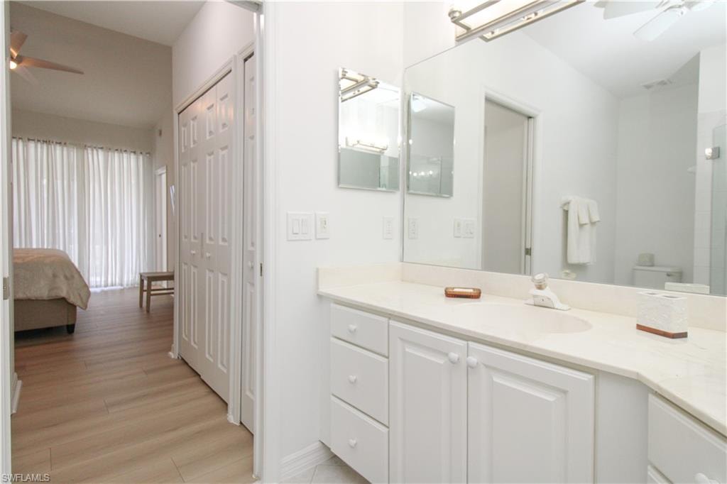 Bathroom with ceiling fan, toilet, vanity, and hardwood / wood-style flooring